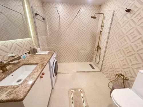 a bathroom with a shower and a sink and a toilet at Sunny Spot Batumi in Batumi