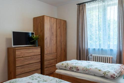 a bedroom with two beds and a tv on a dresser at Green House in Banka
