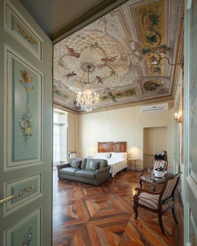 a living room with a couch and a bed with a ceiling at Hotel Roma e Rocca Cavour in Turin