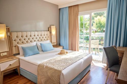 a hotel room with a large bed and a window at TUI MAGIC LIFE Masmavi in Belek