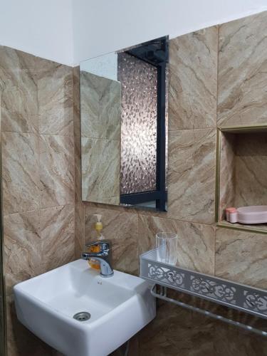a bathroom with a sink and a mirror at MINA CHAI HOUSE BNB in Arusha