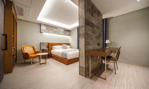 a hotel room with a bed and a desk and chair at Dongdaegu Station Eastern Hotel in Daegu