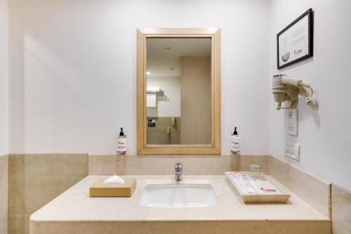 a bathroom with a sink and a mirror at Red Fox by Lemon Tree Hotels, Sector 60, Gurugram in Gurgaon