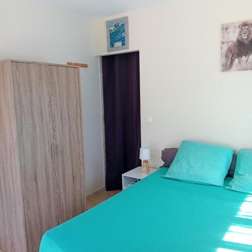 a bedroom with a blue bed and a window at Chez Nathalie in Le Luc