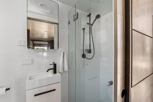 a white bathroom with a sink and a shower at Trackside Tiny Home in Augusta