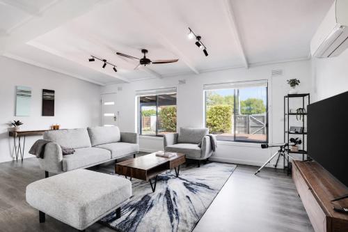 a living room with a couch and a table at Solander in Dromana with Private Spa by Ready Set Stay in Dromana