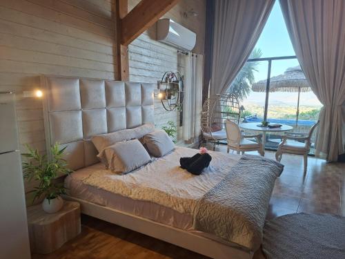 a bed with a black cat sitting on it in a room at צימר תומר דבורה-קצה ההר in Kerem Ben Zimra