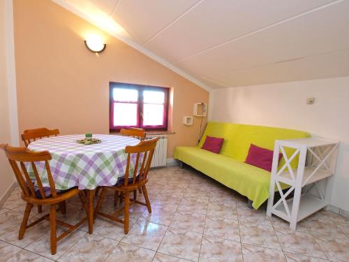 een eetkamer met een tafel en een bed bij Apartments Orange 994 in Fažana