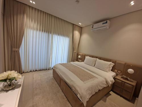 a bedroom with a large bed and a large window at Sifah Seascape House in Muscat