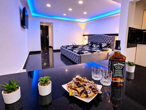 a living room with a table with a bottle of whiskey and snacks at Yoa apartaments in Deva
