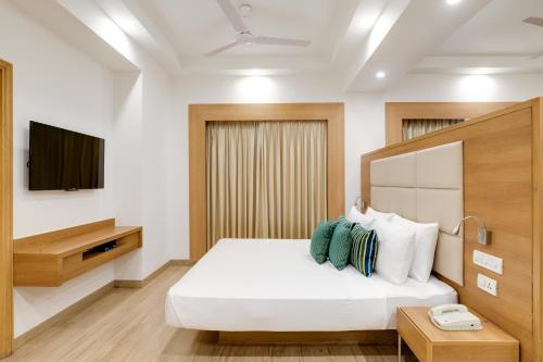 a hotel room with a bed and a television at Lemon Tree Hotel, Sector 60, Gurugram in Gurgaon