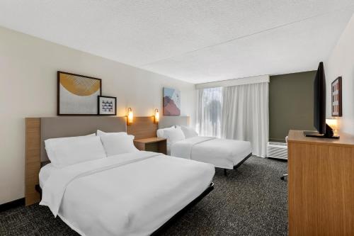 a hotel room with two beds and a desk at Spark By Hilton Akron Fairlawn in Fairlawn