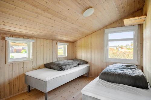 two beds in a wooden room with two windows at FJ1601-Jaegerspris-Strandleddet-25 in Jægerspris