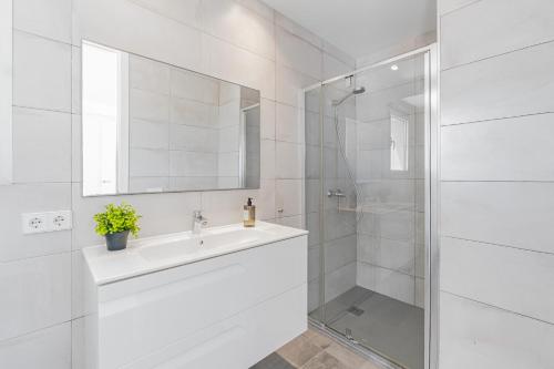 a white bathroom with a sink and a shower at Son Serra Relax 2 By homevillas360 in Son Serra de Marina