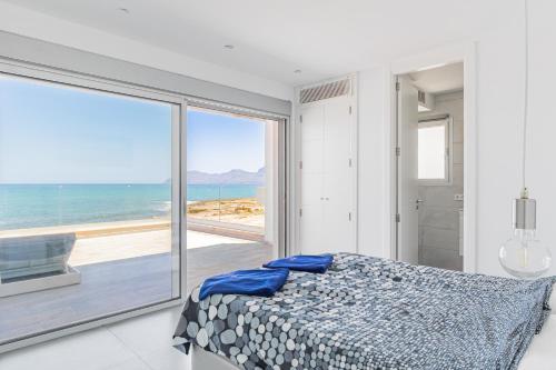 a bedroom with a bed with a view of the ocean at Son Serra Relax 2 By homevillas360 in Son Serra de Marina