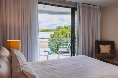 a bedroom with a bed and a view of the ocean at 201 - Ocean Views Oceanfront Large Balcony in Suva