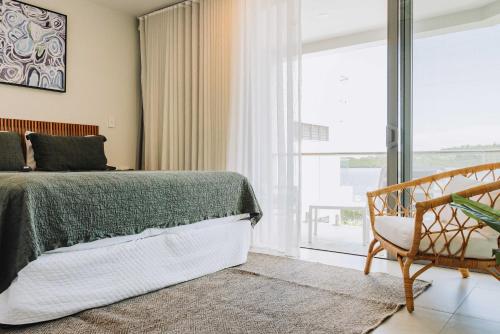 a bedroom with a bed and a chair and a window at 202 - Ocean Views Oceanfront Large Balcony in Suva