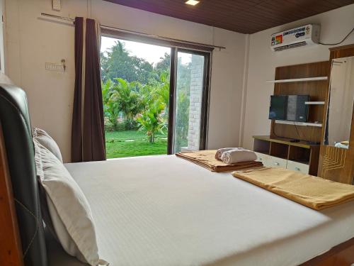 a room with a bed and a large window at Mermaid Avisa in Arambol