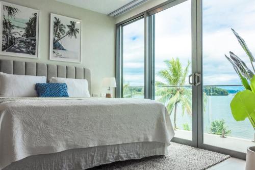 a bedroom with a bed with a view of the ocean at 307 - Suva City Views Oceanfront Large Balcony in Suva