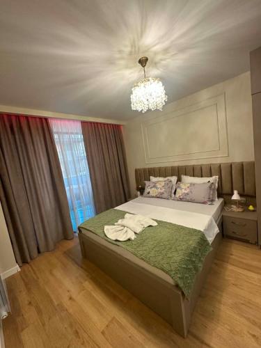 a bedroom with a bed and a chandelier at Rainbow Residence Batumi in Batumi