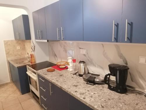 a kitchen with blue cabinets and a counter top at Blue Marianthi in Ávdhira