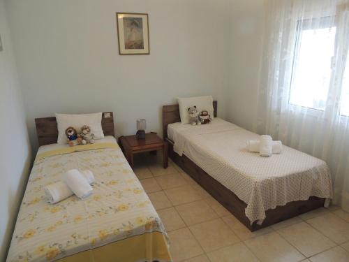 a bedroom with two beds with teddy bears on them at Blue Marianthi in Ávdhira