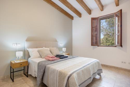 a bedroom with a large bed with a window at Villa Biniali Costitx in Costitx