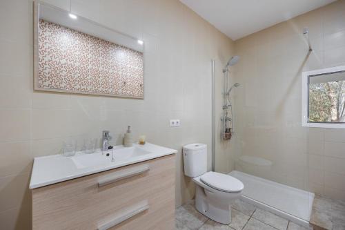 a white bathroom with a toilet and a sink at Villa Biniali Costitx in Costitx