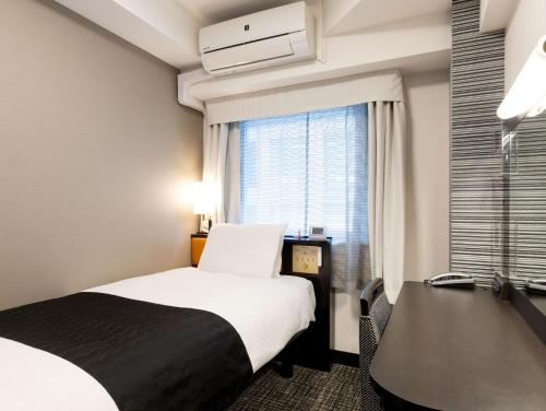 a hotel room with a bed and a window at APA Hotel Kyoto Ekimae Chuoguchi in Kyoto