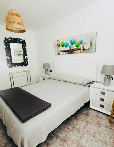 a white bedroom with a bed and a mirror at Casa TIN TIN Lanzarote in Tías
