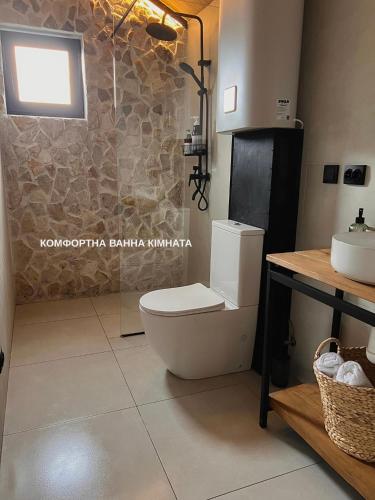 ein Badezimmer mit Toilette und Waschbecken in der Unterkunft Barn 25 in Chornomors'ke