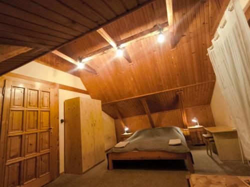 a bedroom with a bed and a wooden ceiling at Privat U Milana Hlavná 316 in Ždiar