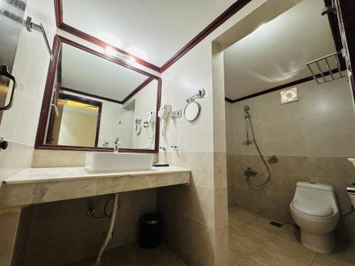 a bathroom with a sink and a toilet and a mirror at Uni Resort in Cox's Bazar