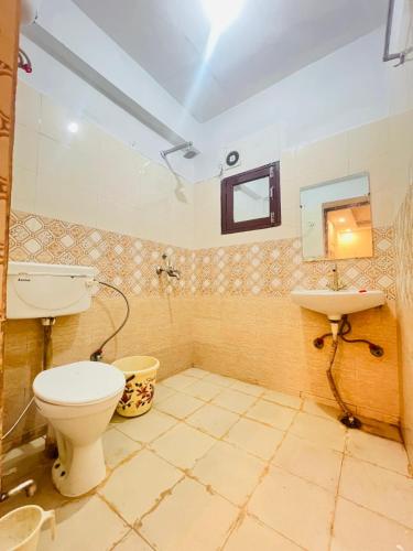 a bathroom with a toilet and a sink at Hotel Comfy Point - Sec 44 Noida in Noida