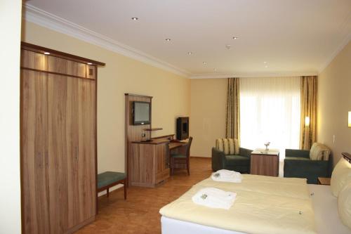 a hotel room with a bed and a living room at Wald-Hotel Heppe in Dammbach