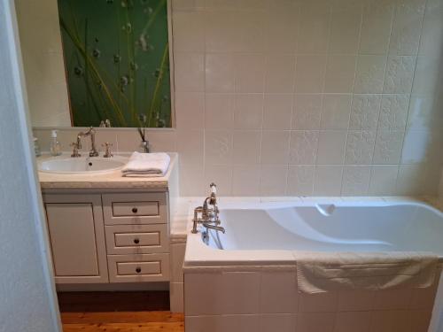 a bathroom with a bath tub and a sink at Caux Loc' du Manoir in Graincourt