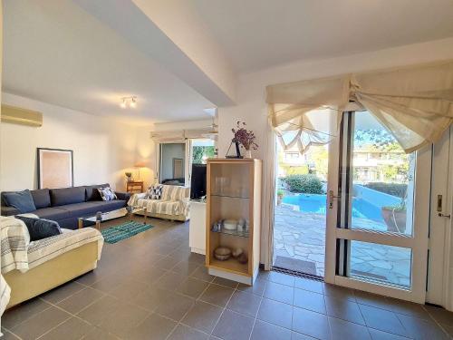a living room with a couch and a sliding glass door at Cosy Garden Flat, Beach, Pool in Plépi