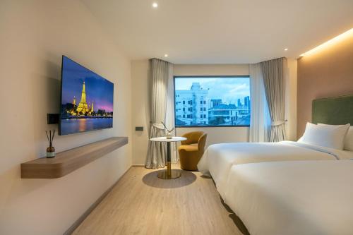 a hotel room with a bed and a window at ROYS Hotel Bangkok in Bangkok