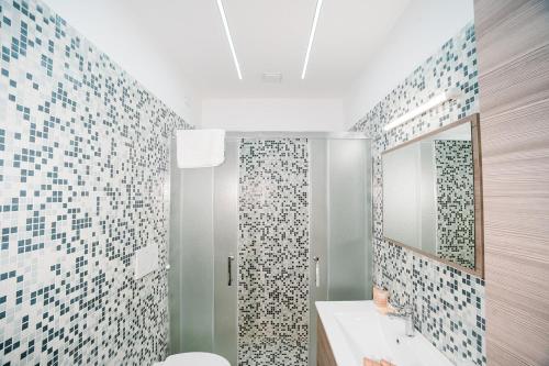 a bathroom with a shower and a toilet and a mirror at Affitta camere LUNAR in Borgo
