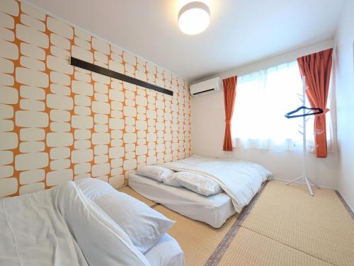 a bedroom with two beds and a large window at Maison New River B-203 in Chiharachō