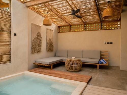 a room with a pool and a couch and a table at HAMA Villa with private pool in El Nido