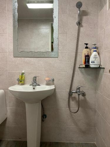a bathroom with a sink and a shower with a mirror at 신화펜션 in Koryŏng