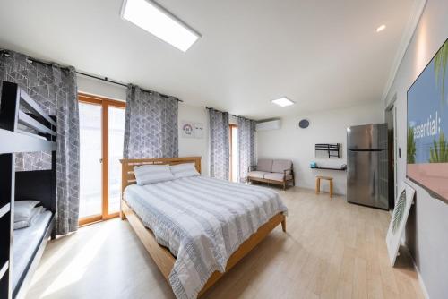 a bedroom with a bed and a refrigerator in it at Yangyang Widaehan Guest in Yangyang