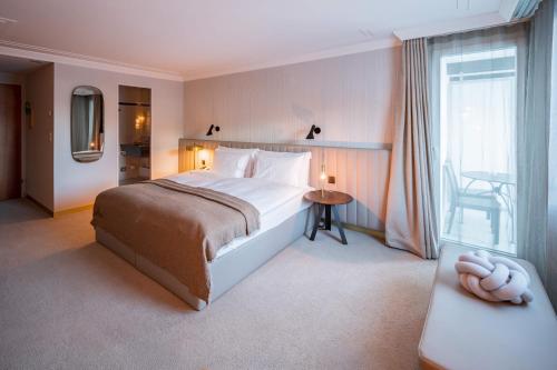 a bedroom with a large bed and a window at Kongress Hotel Davos in Davos