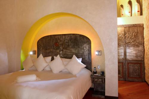 ケレタロにあるCasona de la Republica Hotel Boutique & SPAのベッドルーム1室(大型ベッド1台、アーチ付)