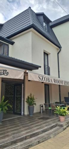 a building with a patio and awning on it at Central Room Hostel in Balatonszárszó