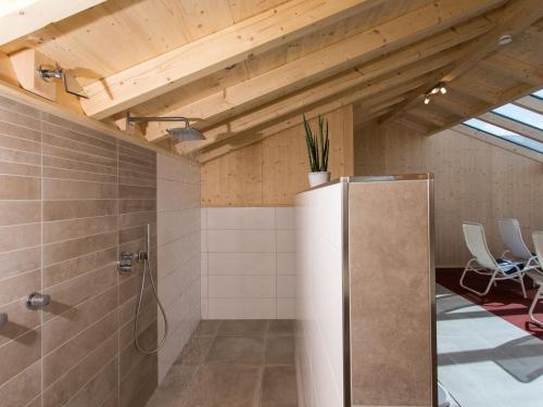a bathroom with a shower and a refrigerator at Saunaloft Schwarzwald in Gemeinde Aichhalden
