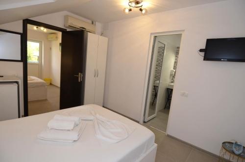 a bedroom with a white bed with towels on it at Harmony Villa in Costinesti