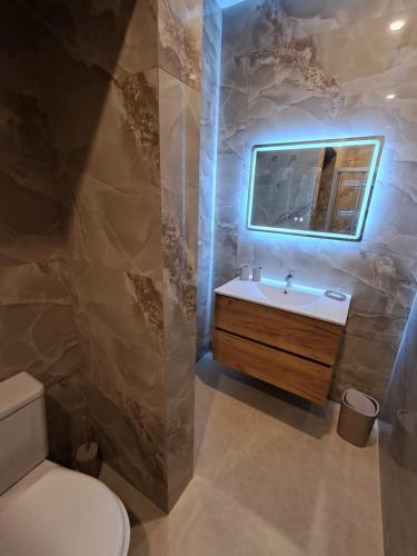 a bathroom with a sink and a toilet and a mirror at Caterina Suites in Wied l-Arkata