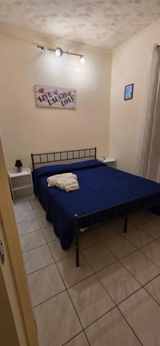 a bedroom with a bed with a blue comforter at Casa Arancio in Tarquinia